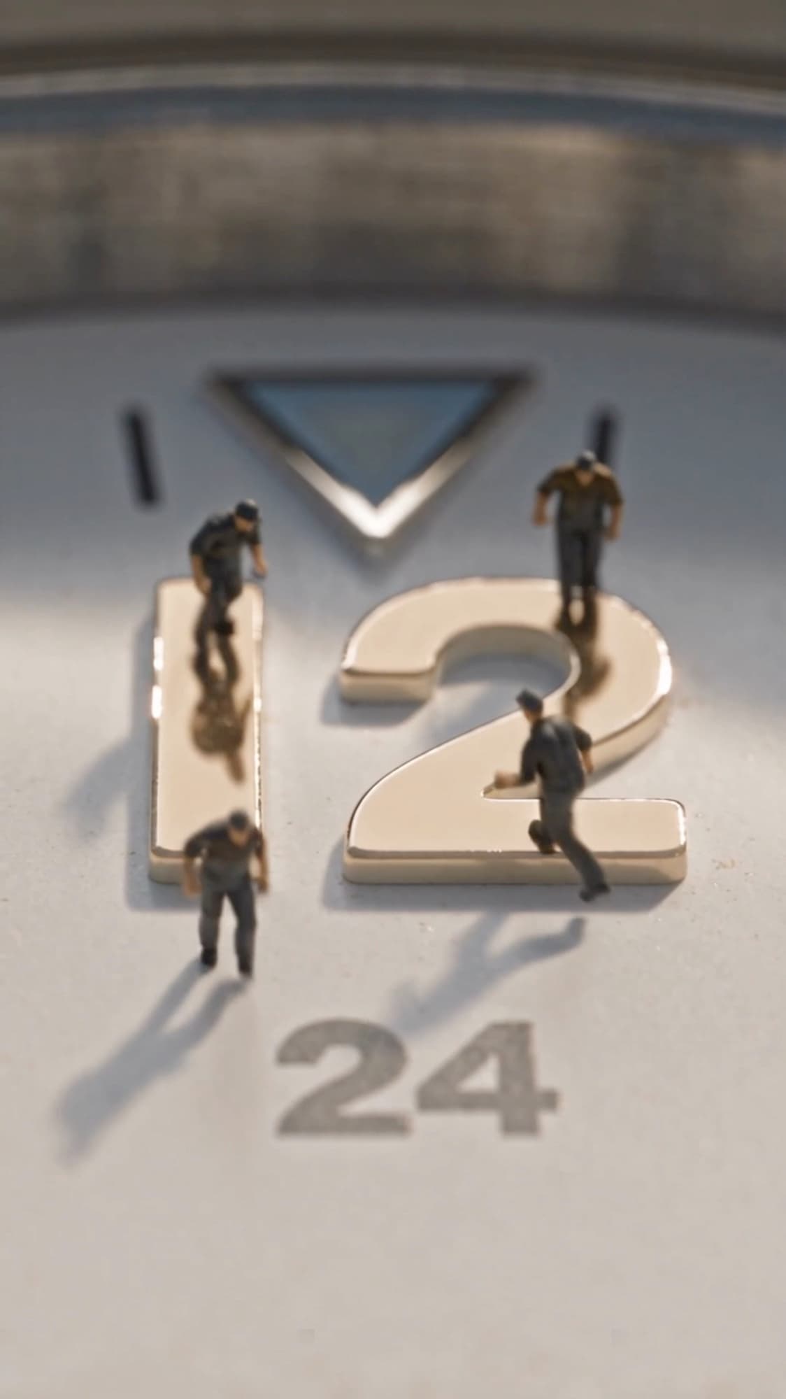 Overhead view of workers crossing the applied twelve o'clock markers, long shadows behind them