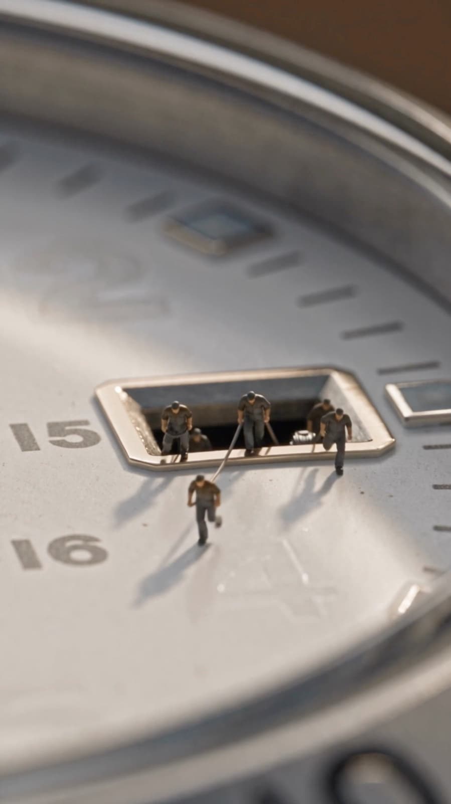 Miniature workers climbing out of the date window of a Seiko 5 Sports GMT dial